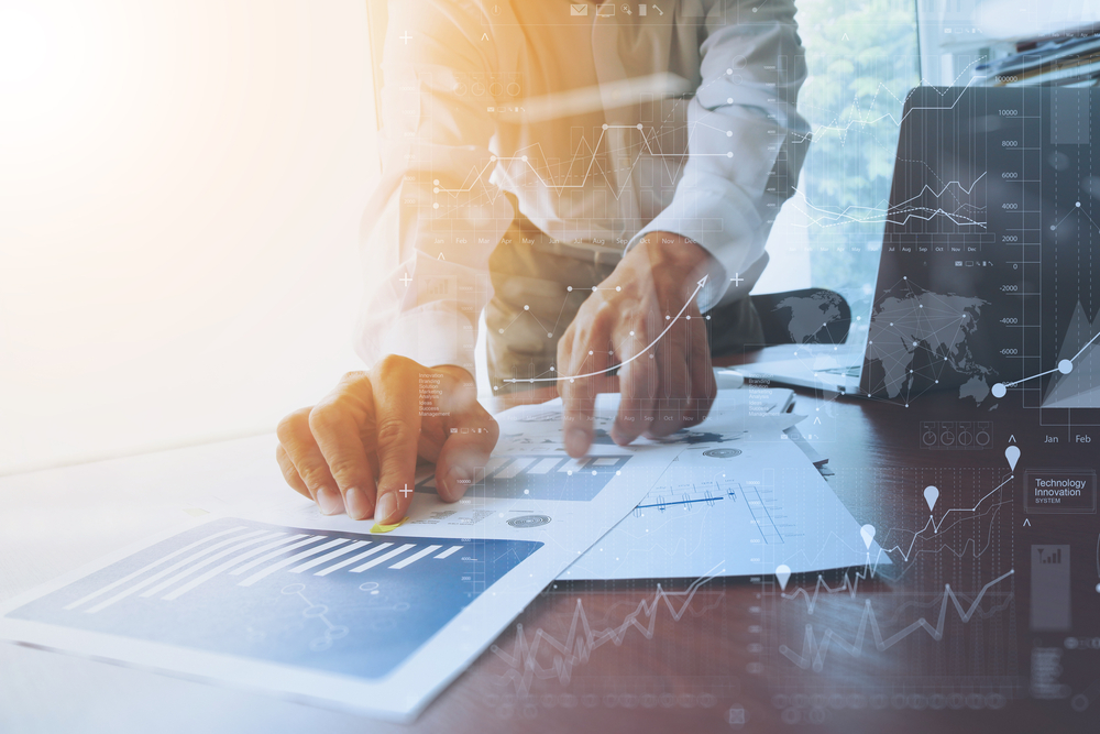 business documents on office table with smart phone and digital tablet and graph financial with social network diagram and man working in the background-1